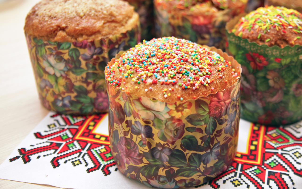 Вкусные сладкие куличи с посыпкой стоят на рушнике