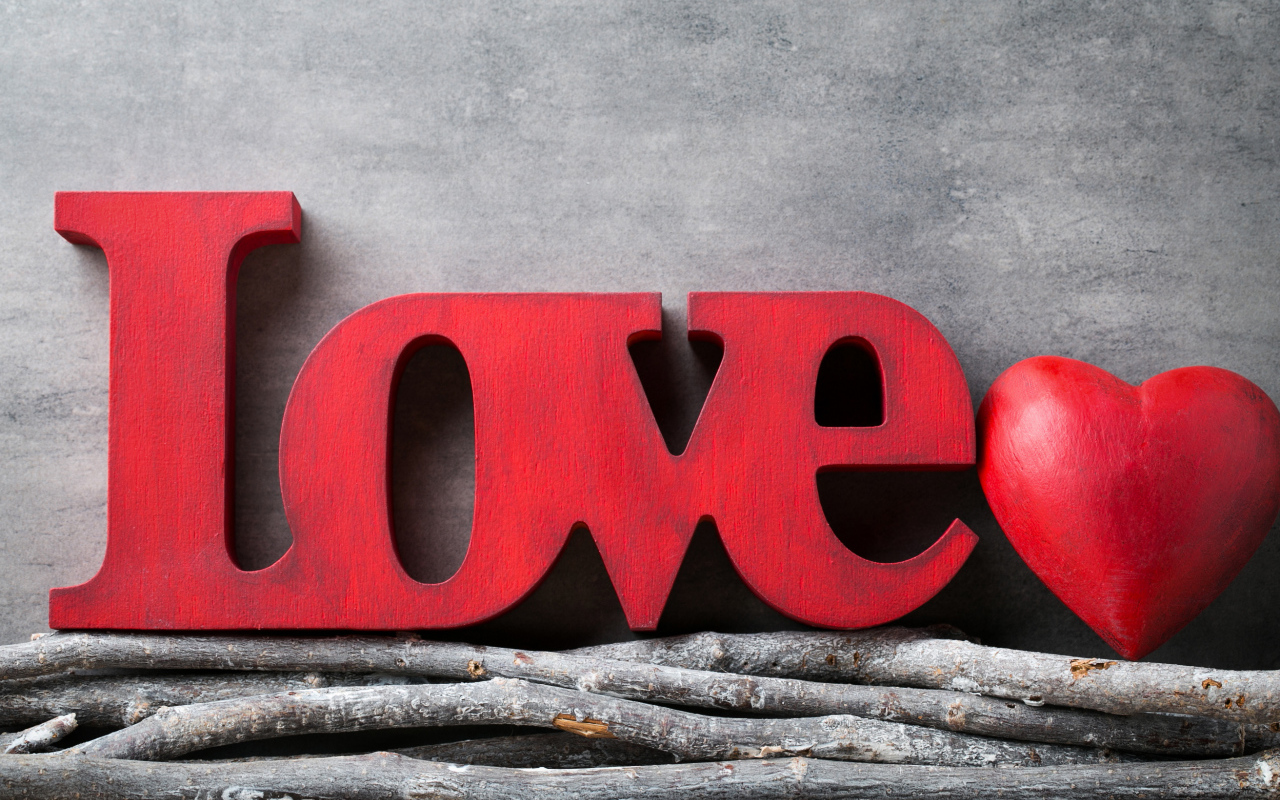 Большая надпись любовь на английском на фоне серой стены 