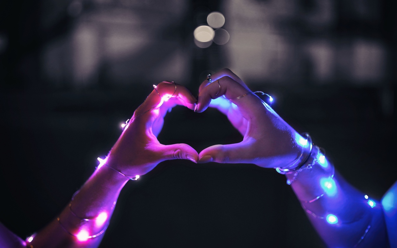 Девушка делает сердце руками