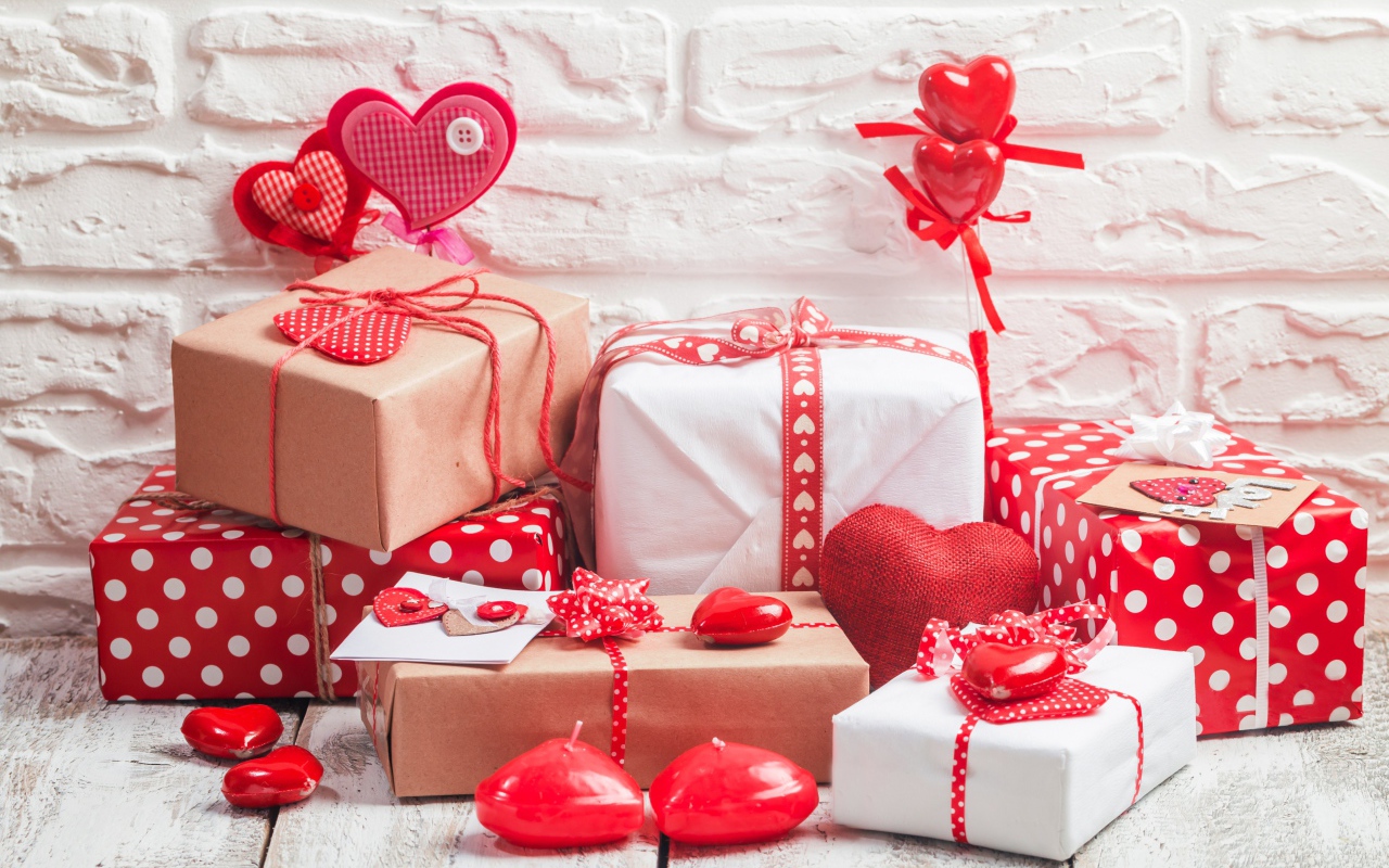 Много  подарочных коробок с сердечками на фоне стены