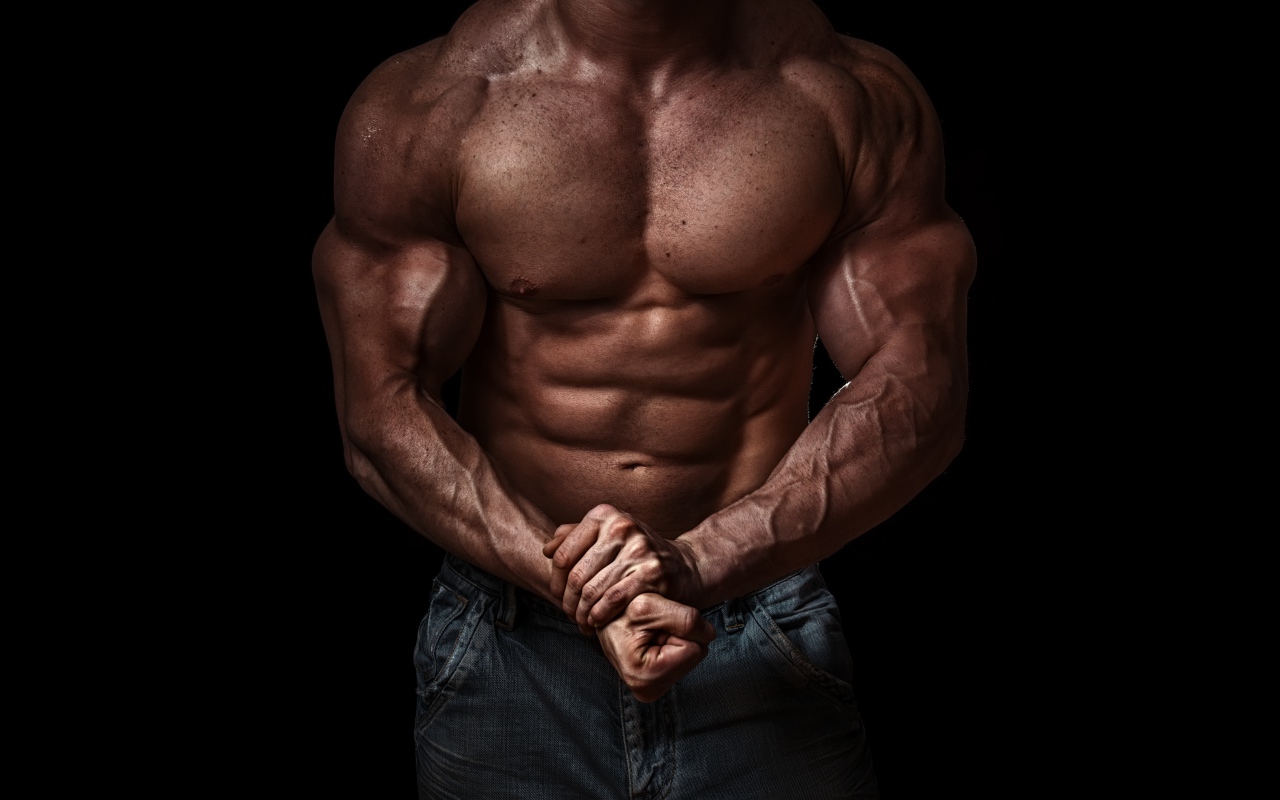 Тело накаченного мужчины на черном фоне