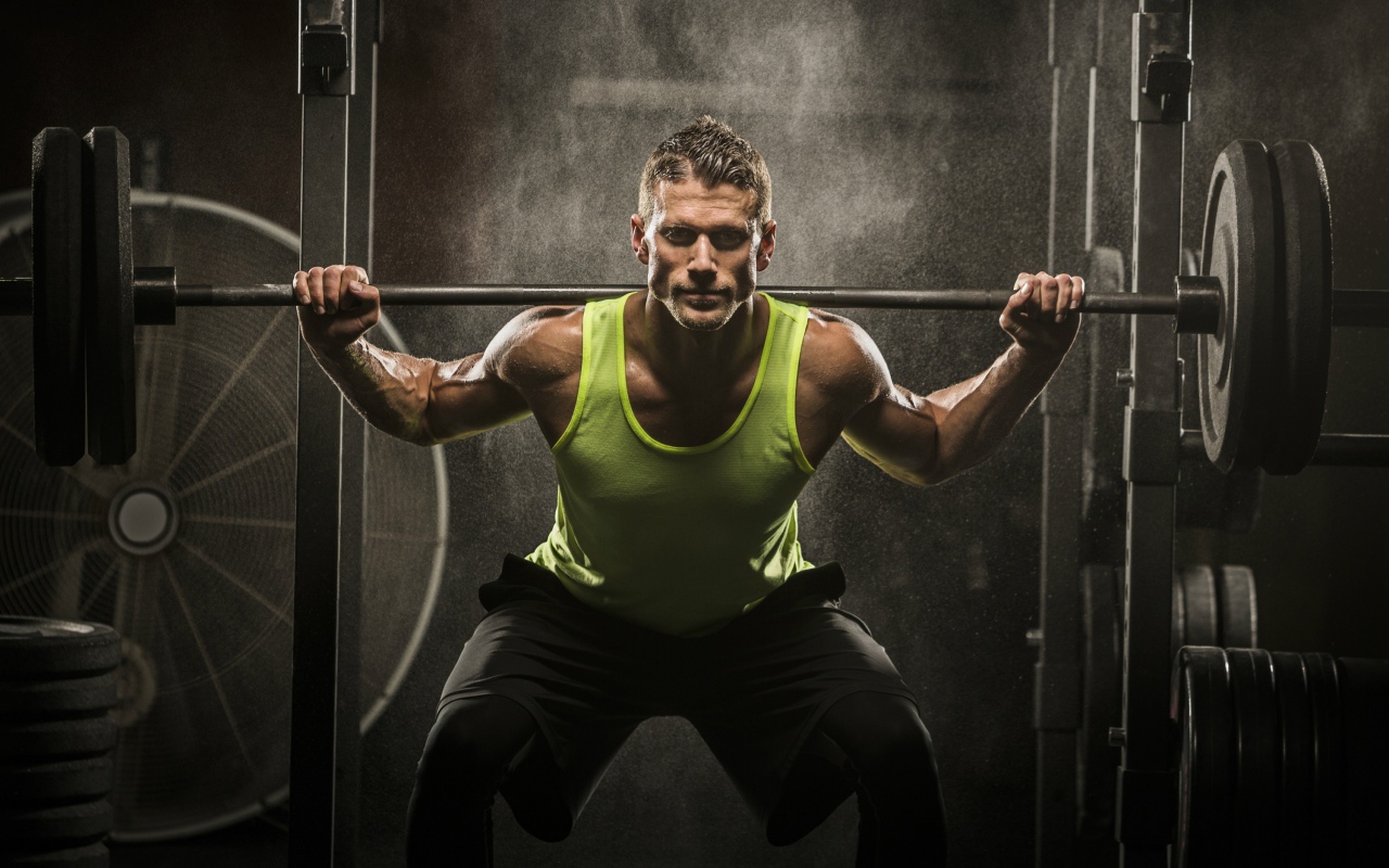 Мужчина спортсмен со штангой на плечах 