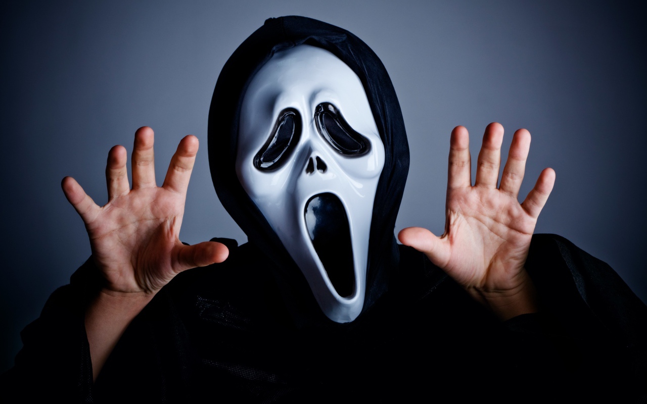 Мужчина в маске пугает на сером фоне