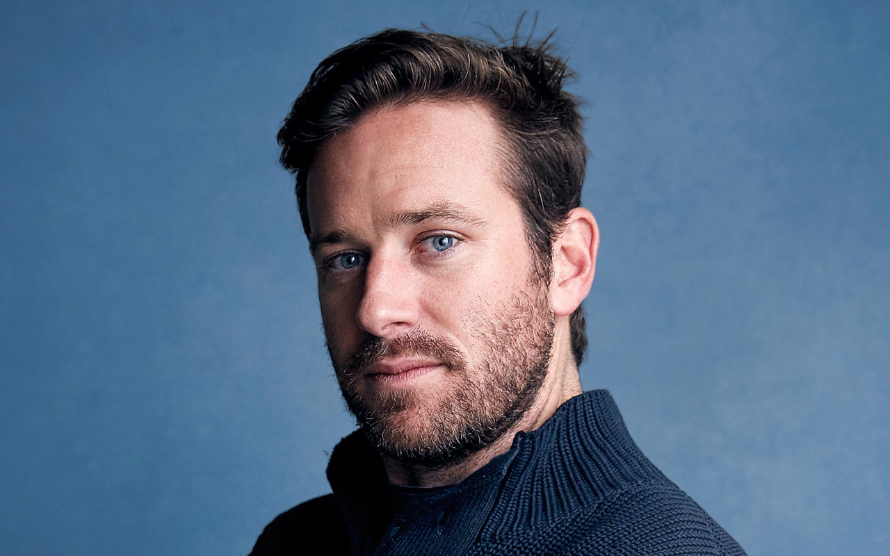 Актер Арми Хаммер на голубом фоне