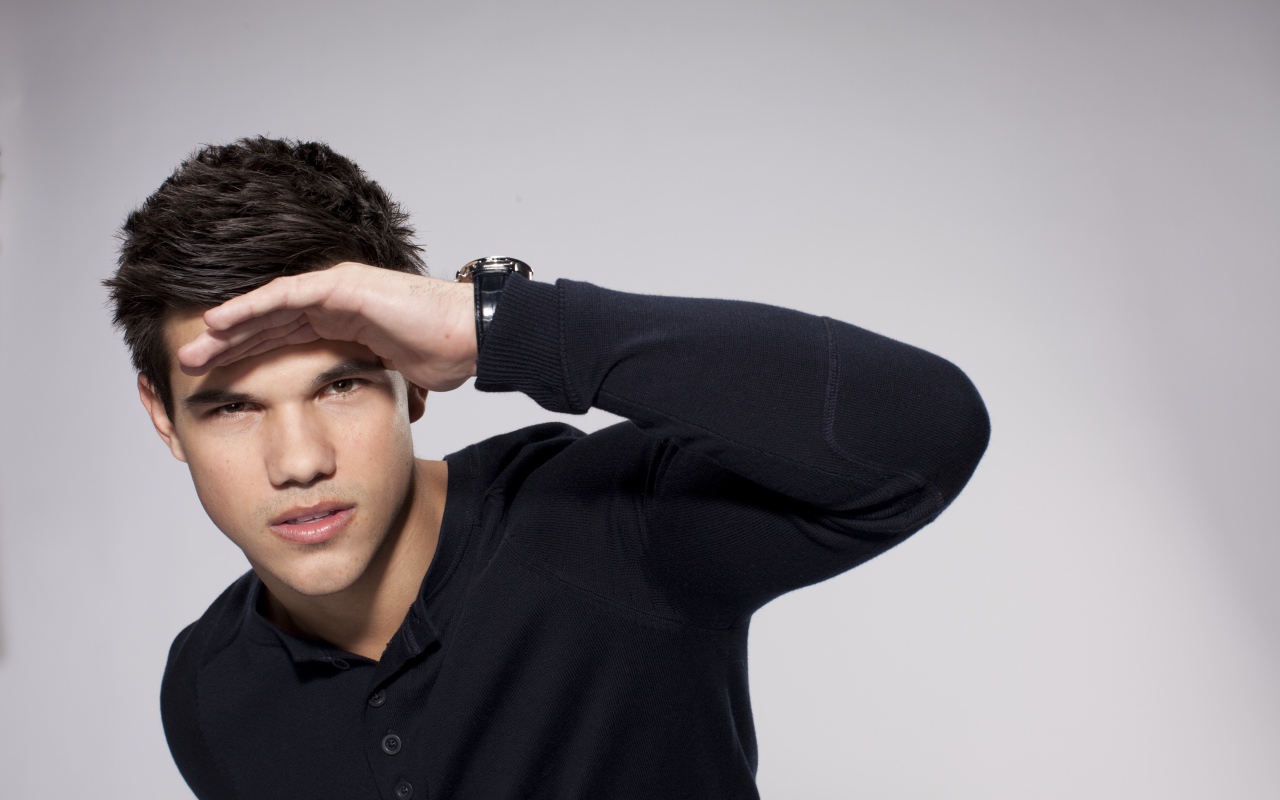 Красивый парень, актер Тейлор Лотнер на сером фоне