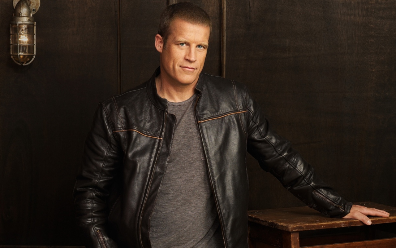 Красивый мужчина, актер Марк Вэлли в кожаной куртке