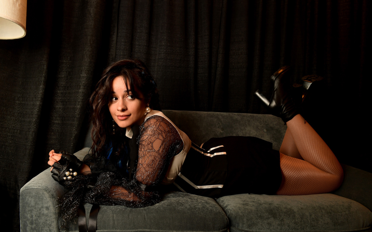 Молодая певица Камила Кабельо лежит на диване