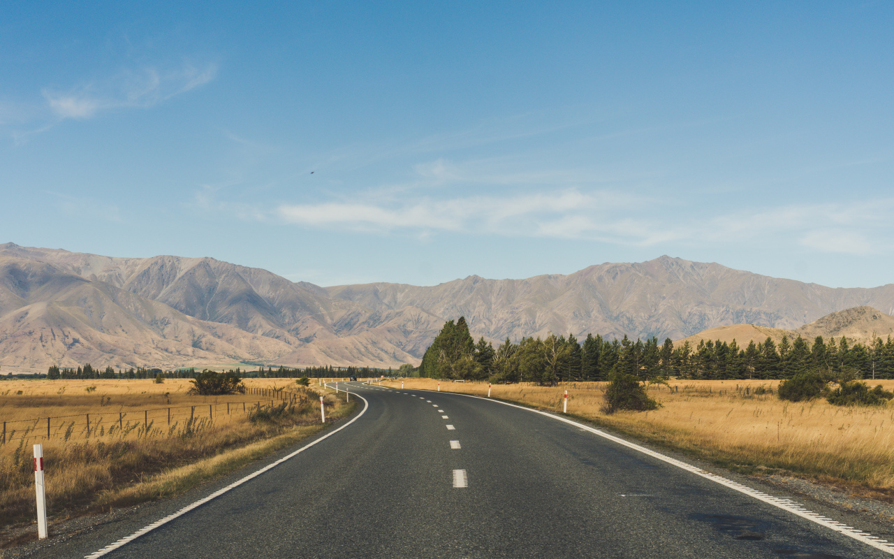 Ровная асфальтовая дорога на фоне гор 