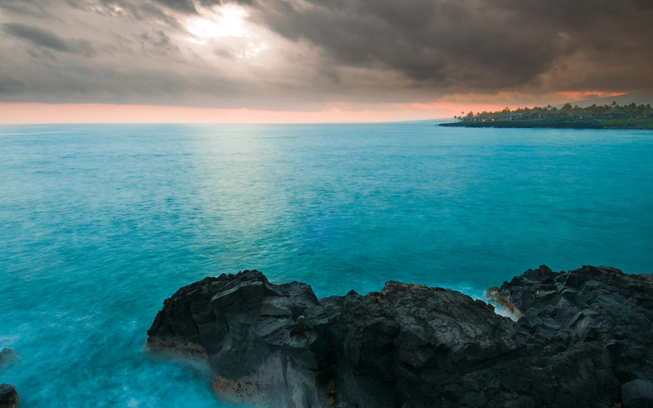 Камни в голубой воде океана под пасмурным небом
