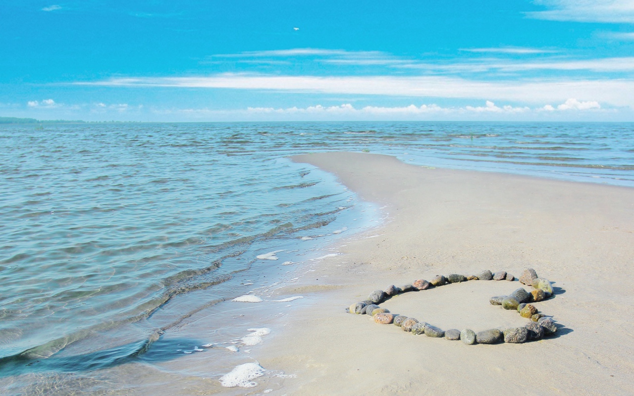 Сердце из камней на берегу теплого моря летом