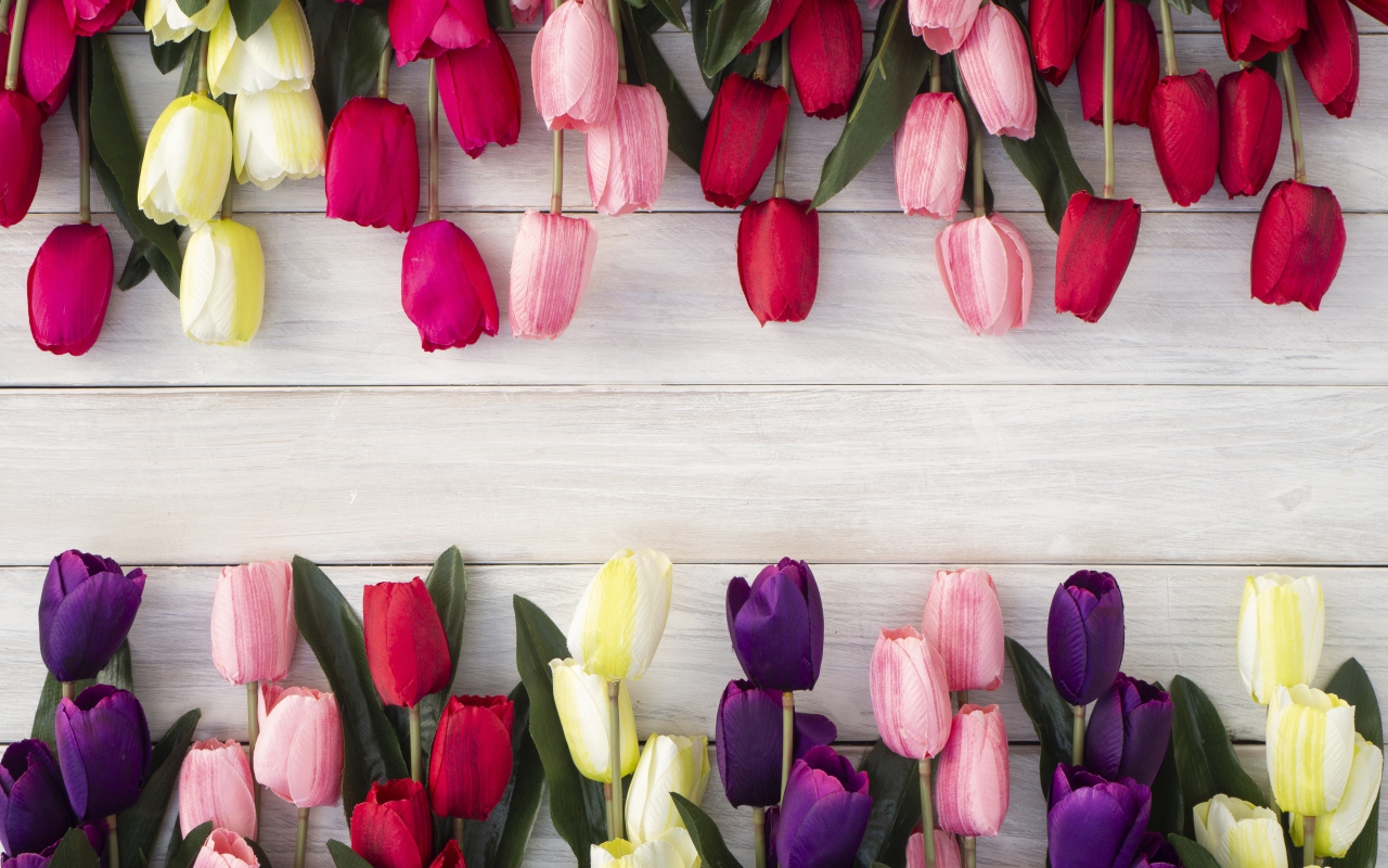 Искусственные разноцветные тюльпаны на деревянной поверхности