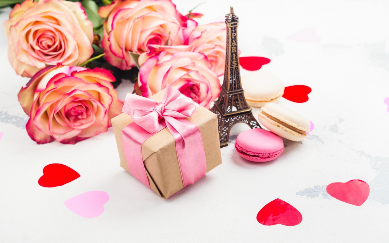 Букет роз на столе с фигуркой Эйфелевой башни и подарком
