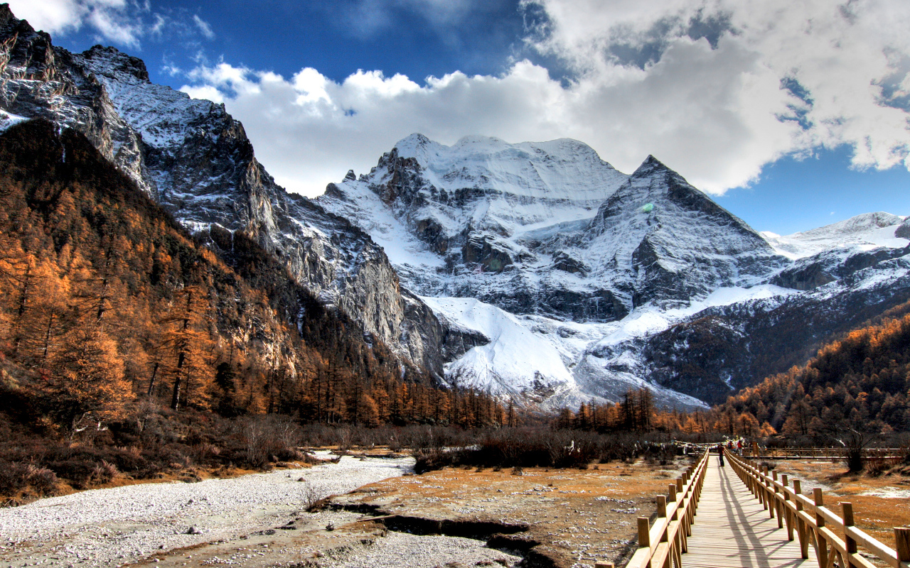 Мост у подножия заснеженных величественных гор