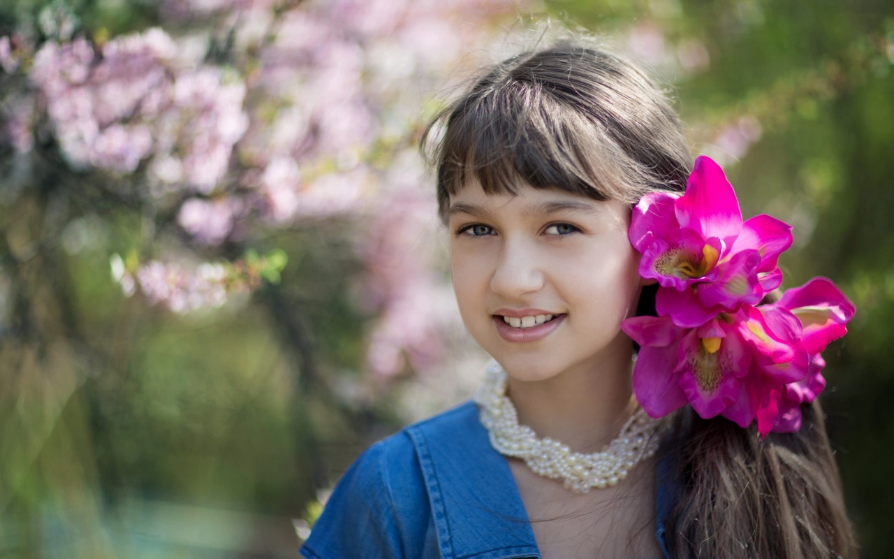 Красивая девочка с розовыми цветами в волосах