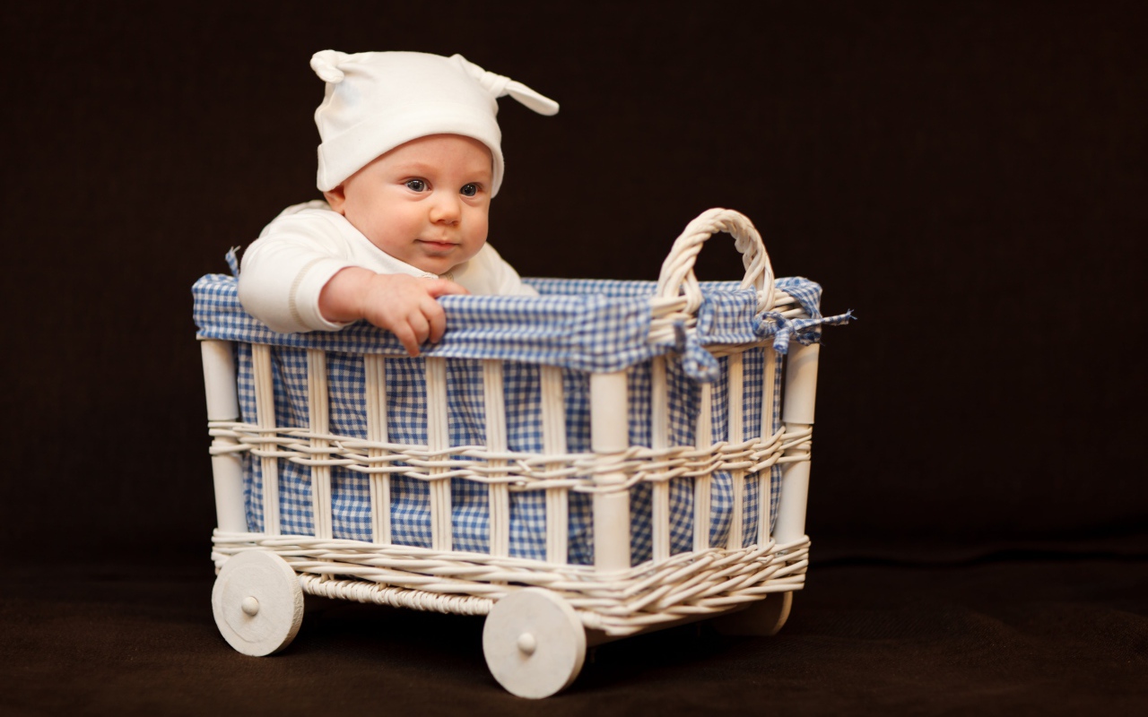 Маленький ребенок в кроватке на колесах 