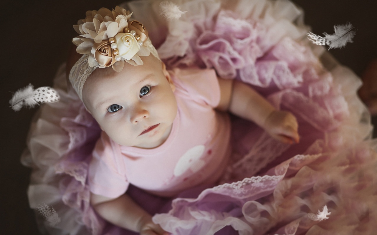 Маленькая милая девочка в пышном платье с повязкой на голове