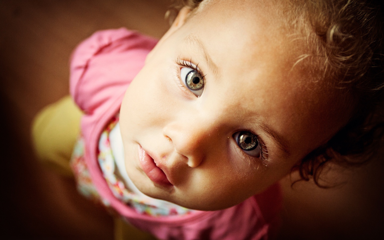 Маленькая девочка крупным планом смотрит вверх 