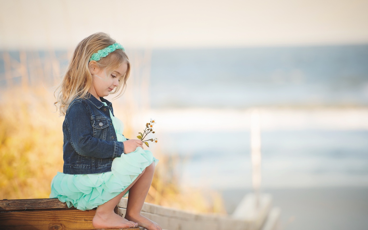 Маленькая девочка сидит на мосту