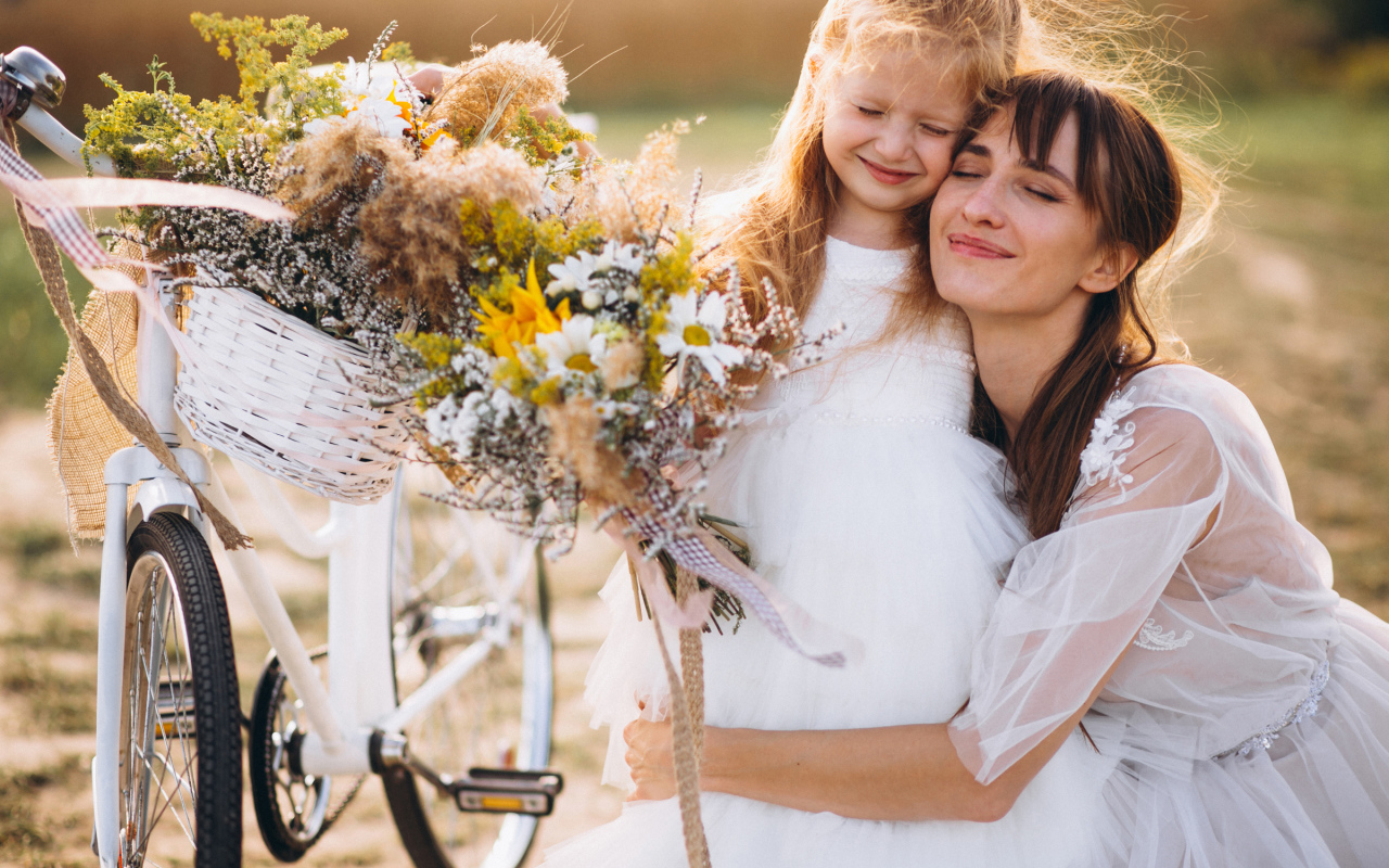 Маленькая девочка с мамой у велосипеда
