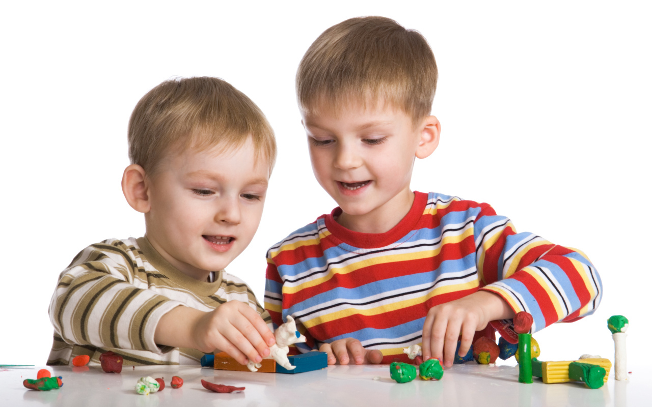 Два мальчика играют в игрушки на белом фоне