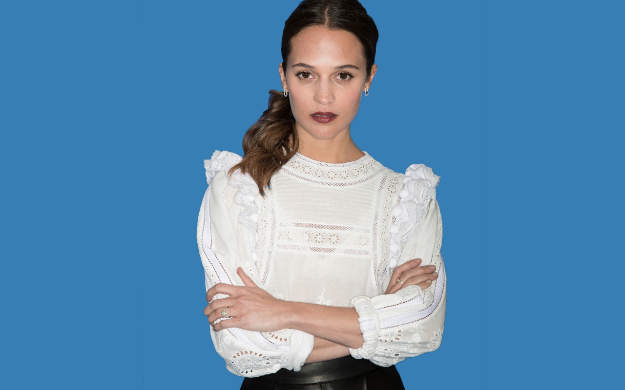Актриса Алисия Викандер в белой блузке на синем фоне