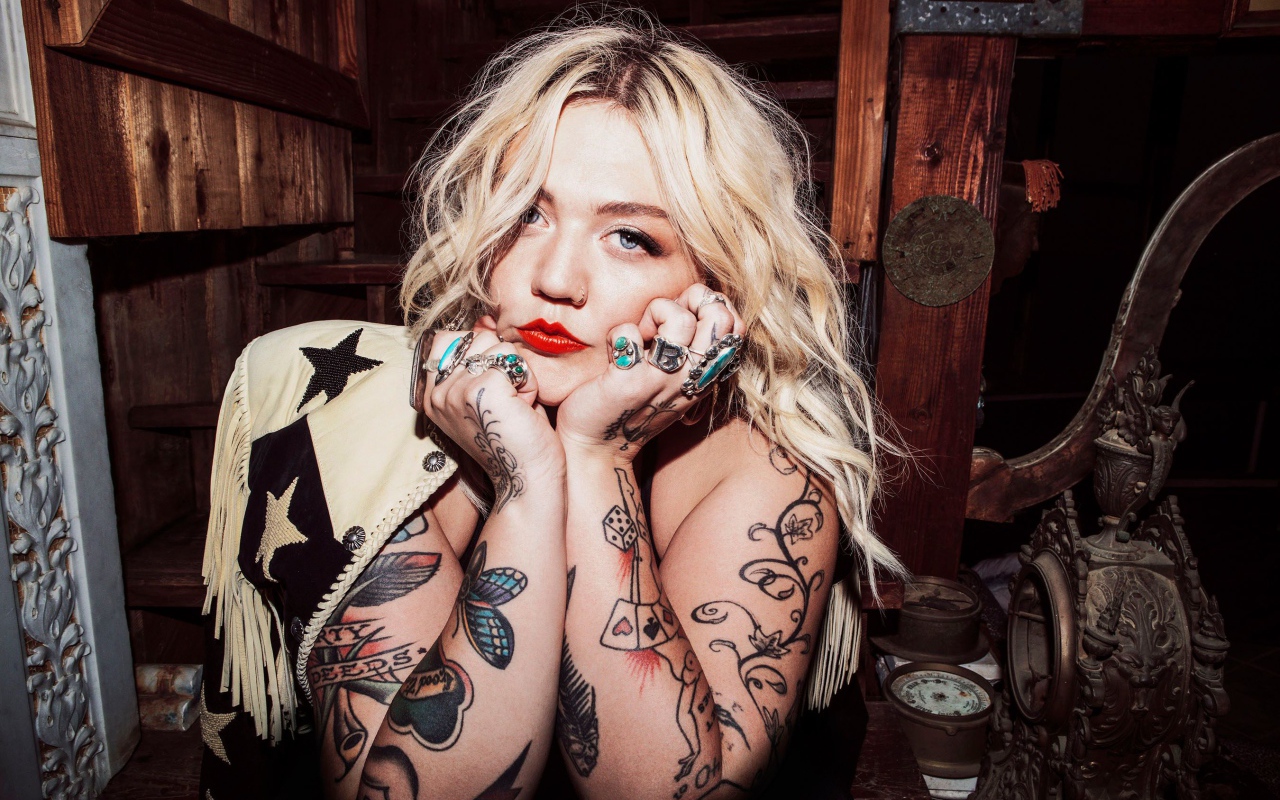 Blue-eyed blonde with tattoos on her arms