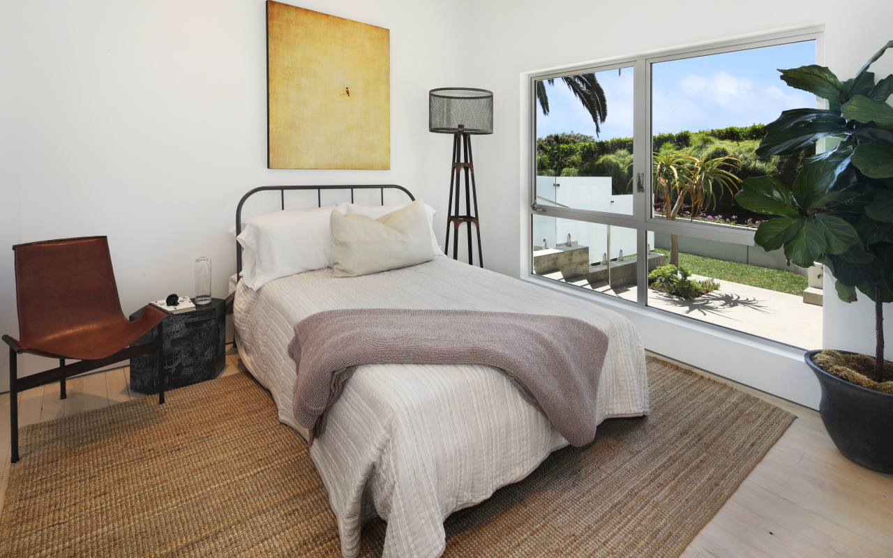 Большая кровать у окна в спальной комнате