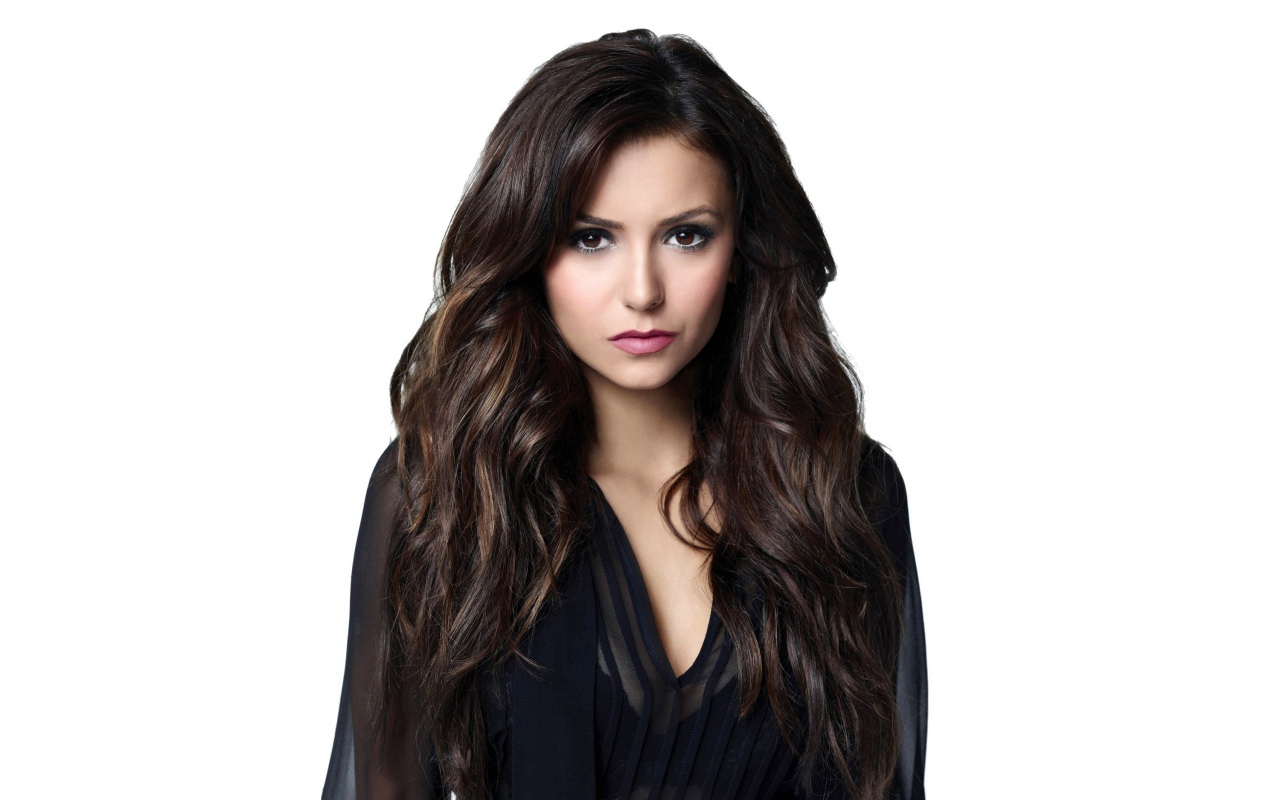 Длинноволосая девушка актриса Нина Добрев на белом фоне