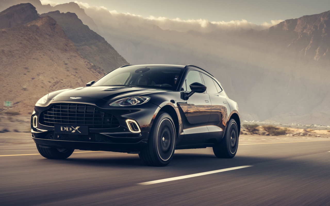 Черный автомобиль Aston Martin DBX 2020 года на трассе