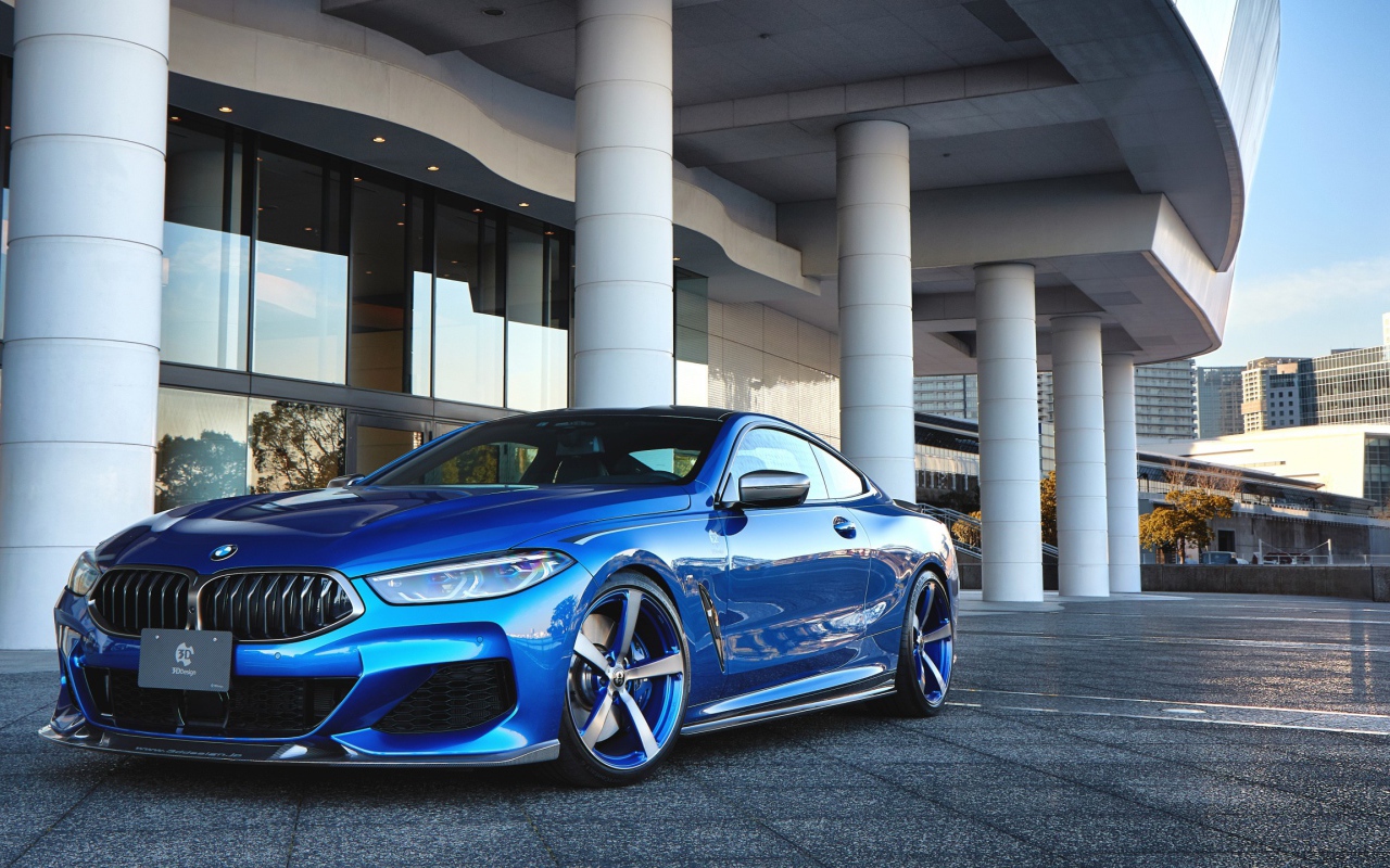Синий автомобиль BMW M850i XDrive Coupe 2020 года у здания 