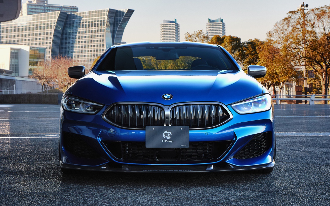 Синий автомобиль  BMW M850i XDrive Coupe 2020 года на фоне города 