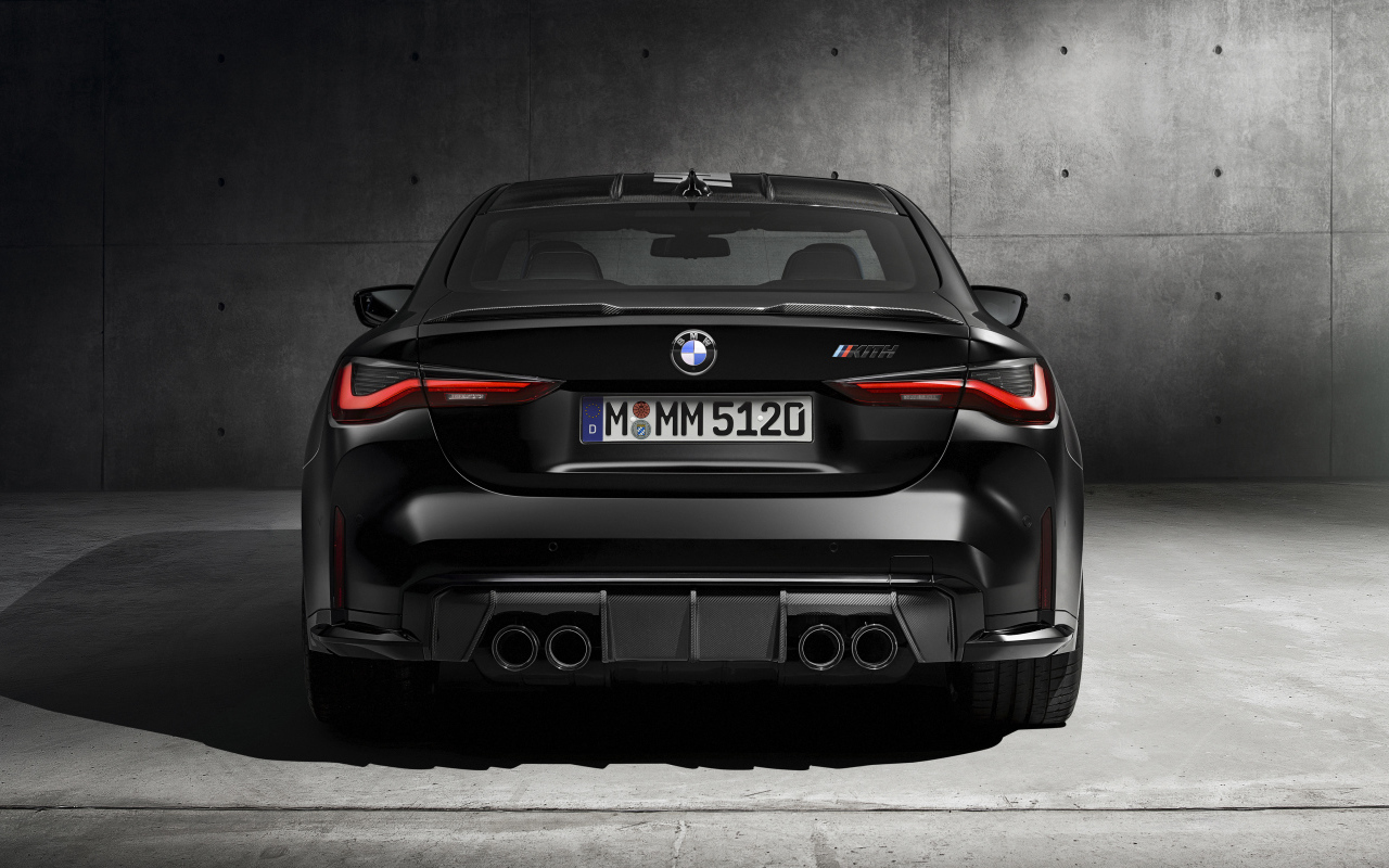 Черный BMW M4, 2021 года вид сзади на сером фоне