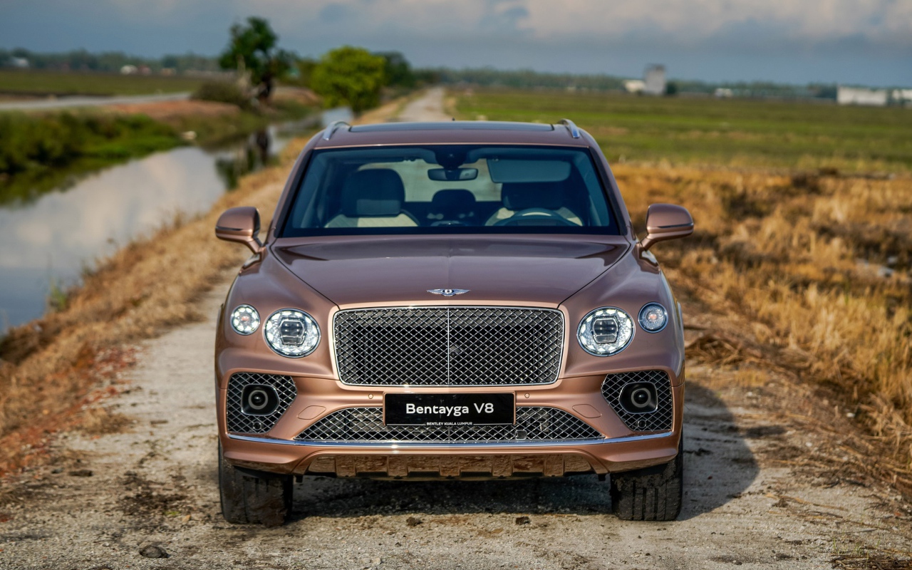 Коричневый автомобиль Bentley Bentayga V8 2020 года у реки