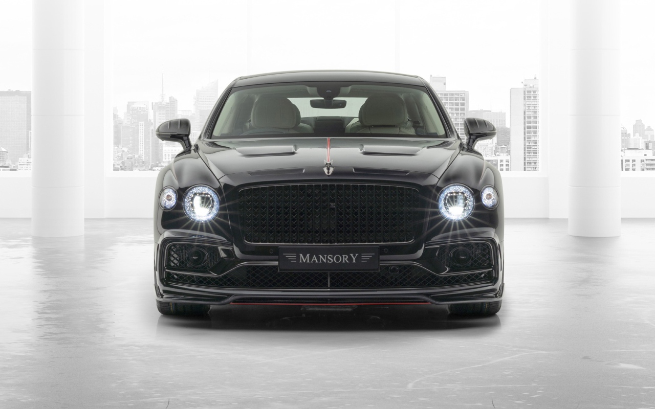 Черный автомобиль Mansory Bentley Flying Spur 2020 года с включенными фарами 