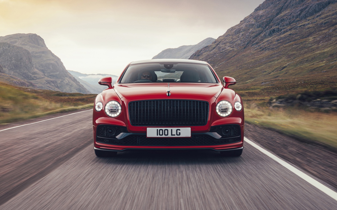 Red 2020 Bentley Flying Spur V8 car on the road in the mountains