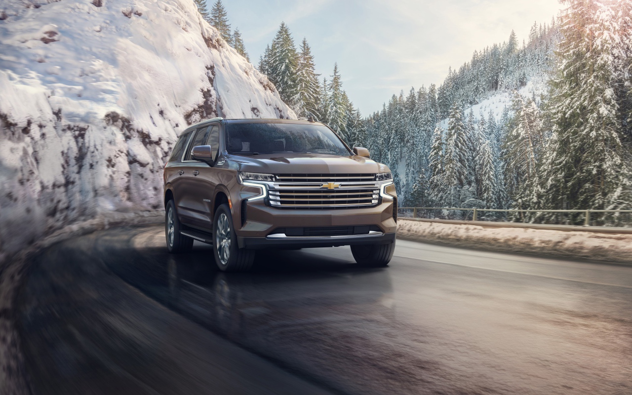 Внедорожник Chevrolet Suburban на фоне заснеженного леса, 2021 года