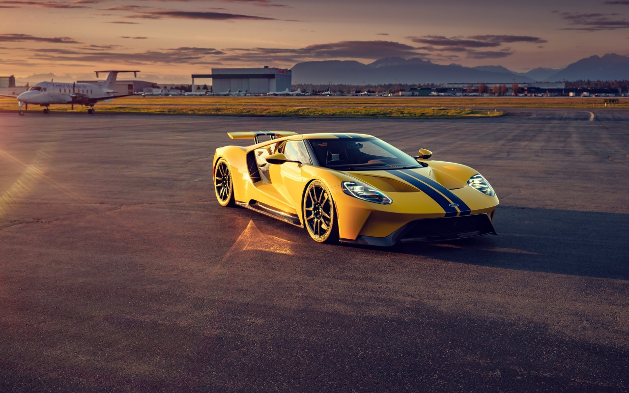 Желтый гоночный автомобиль Ford GT на взлетной полосе 