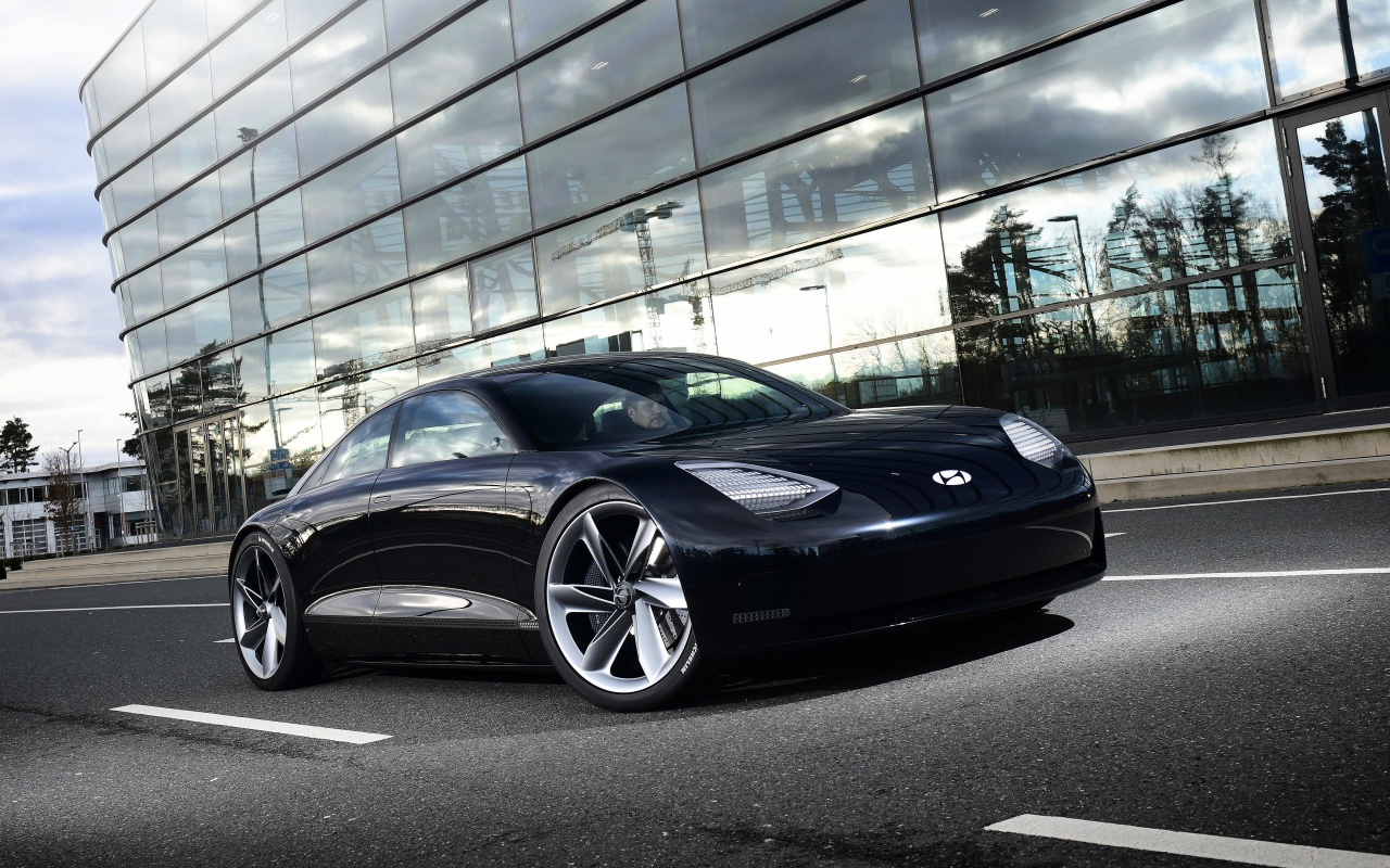 Черный автомобиль Hyundai Prophecy 2020 года у стеклянного здания 