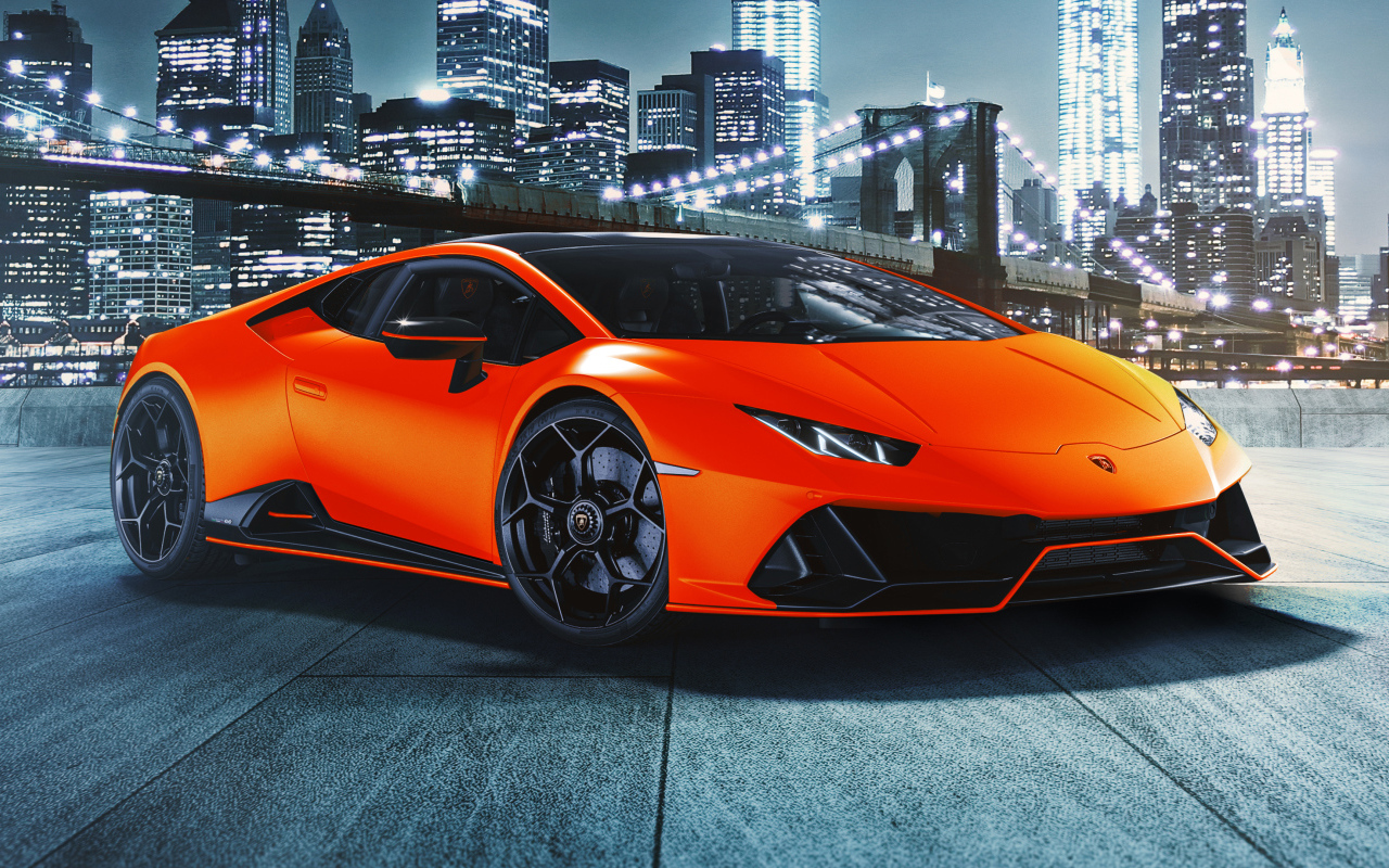 Оранжевый автомобиль Lamborghini Huracán EVO 2021 года на фоне небоскребов