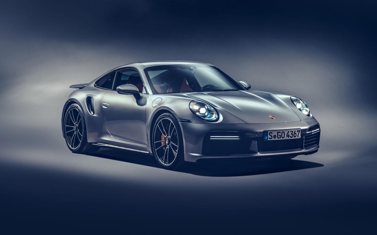 Автомобиль Porsche 911 Turbo S 2020 года на сером фоне
