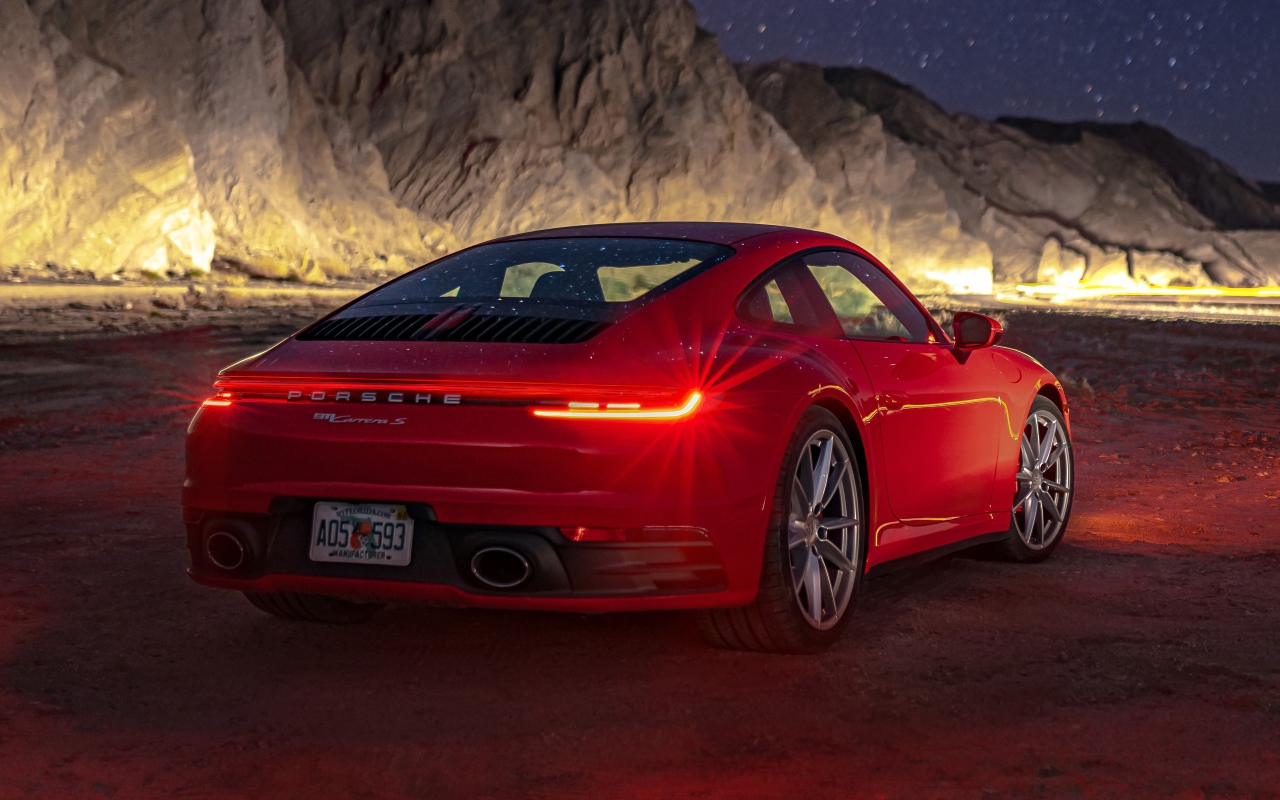 Красный автомобиль  Porsche 911 Carrera S, 2020 года в горах ночью 