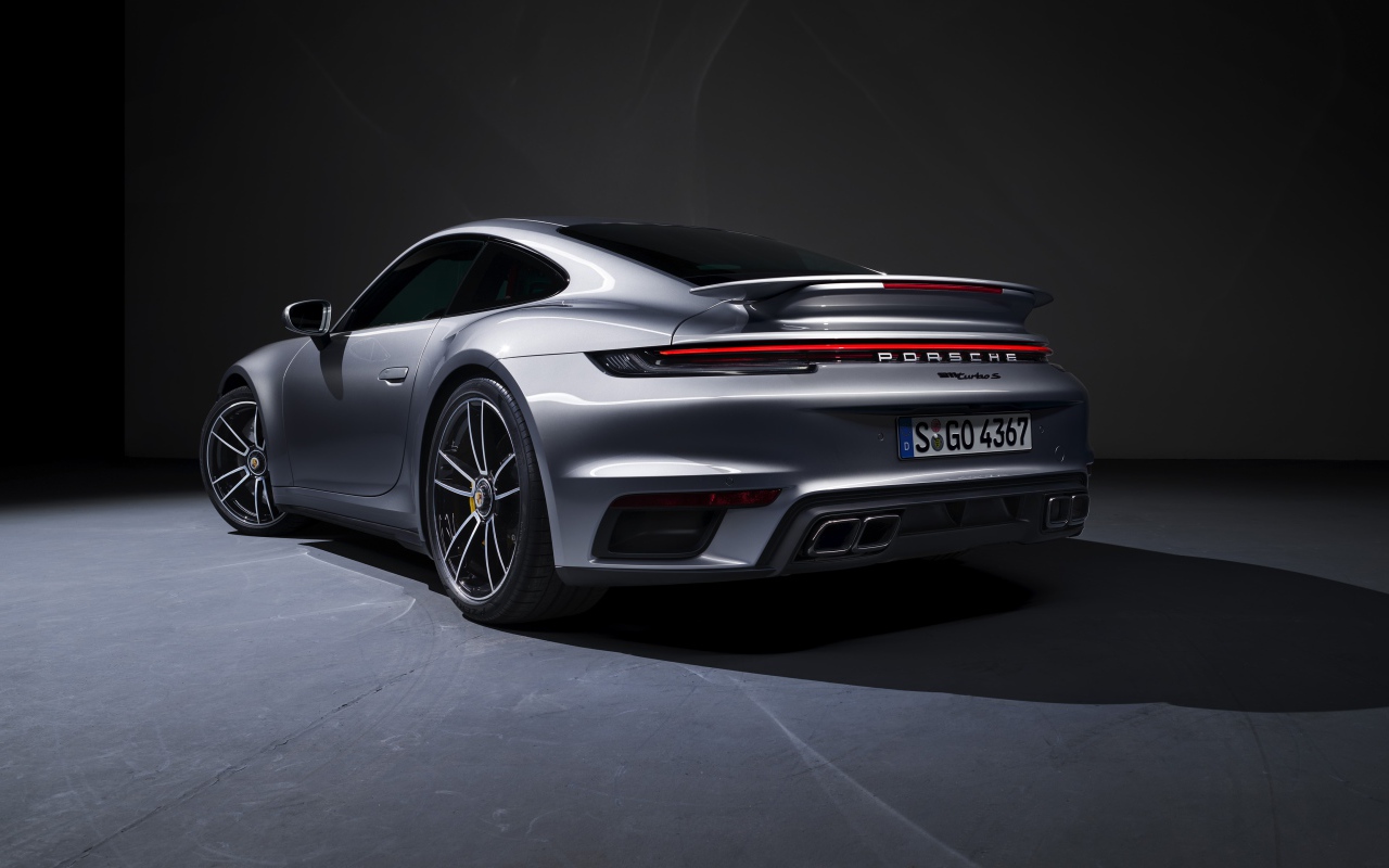 Серебристый автомобиль Porsche 911 Turbo S 2020 года вид сзади