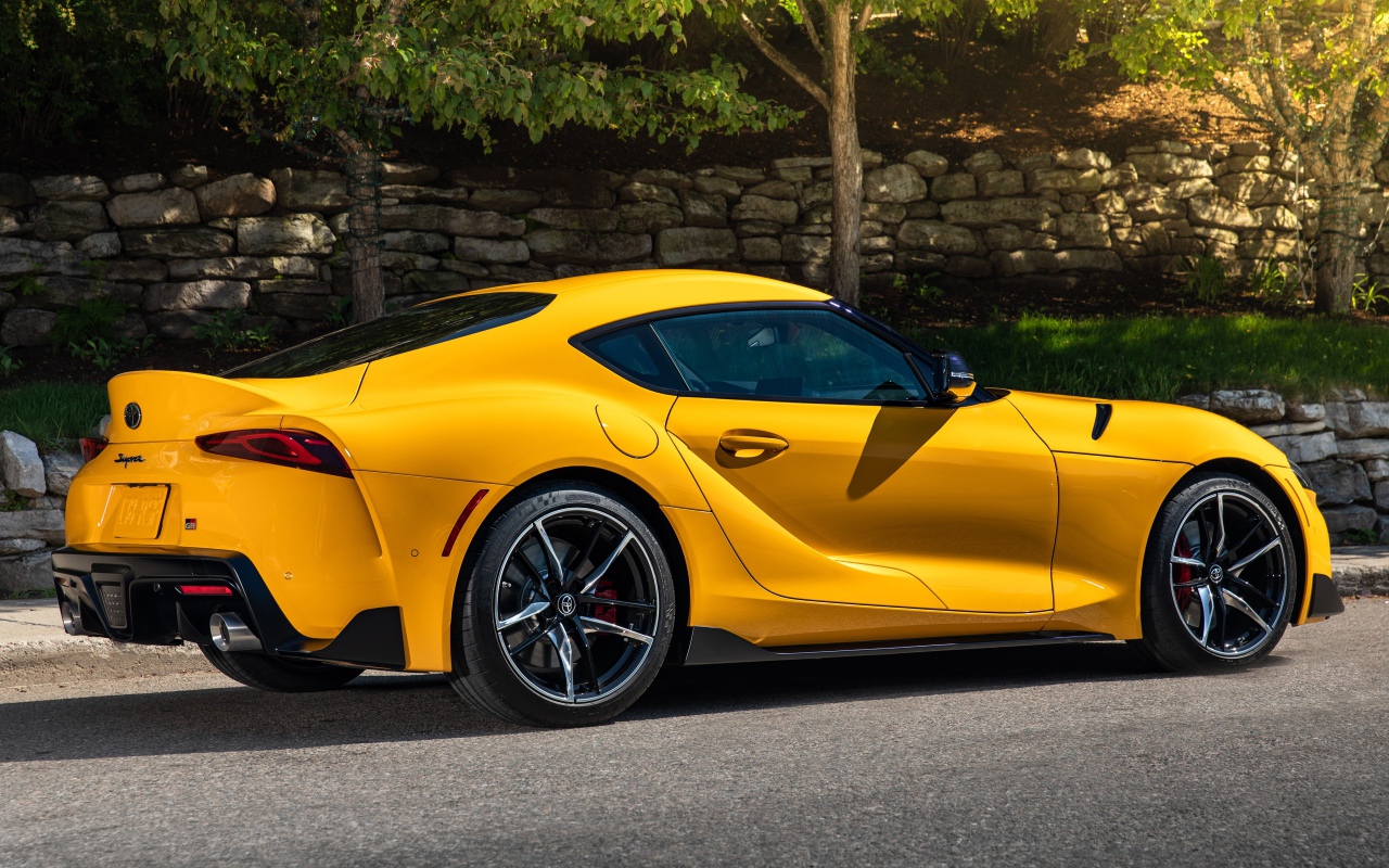 Желтый автомобиль Toyota GR Supra 2, 2021 года вид сбоку 