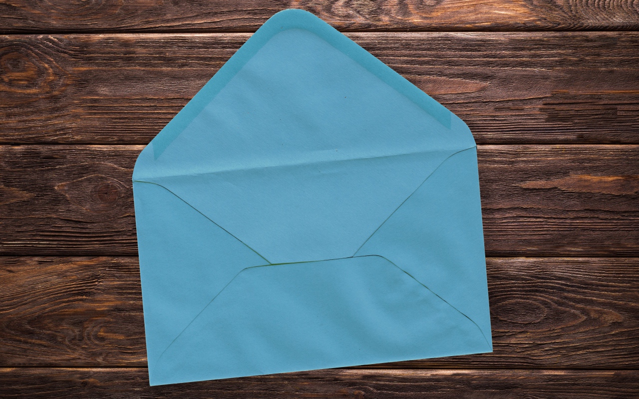 Blue paper envelope on a wooden background