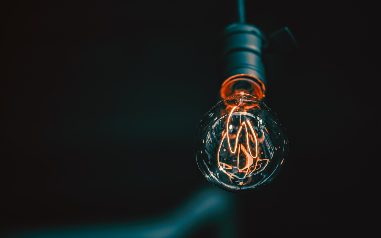 Зажженная лампа накаливания под потолком