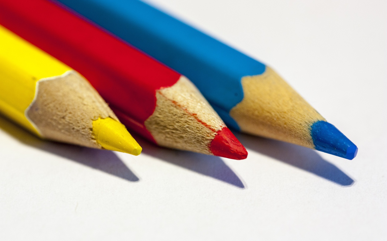Три разноцветных карандаша на белом фоне