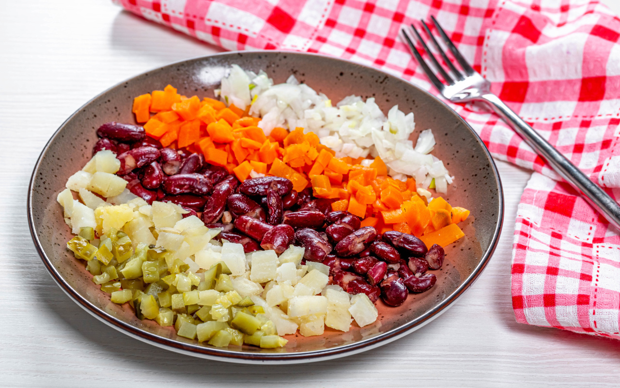 Овощи и фасоль нарезанные на тарелке 