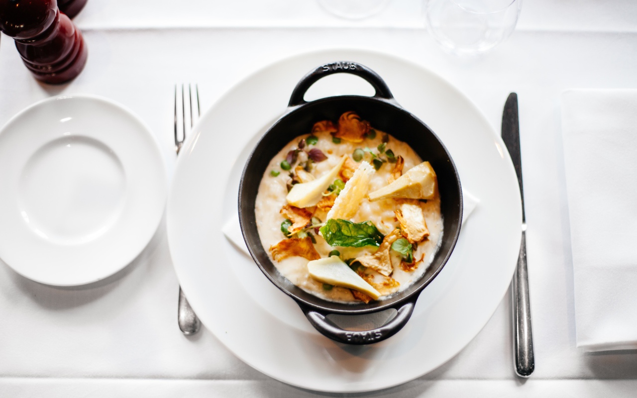 Суп в миске стоит на белой тарелке 