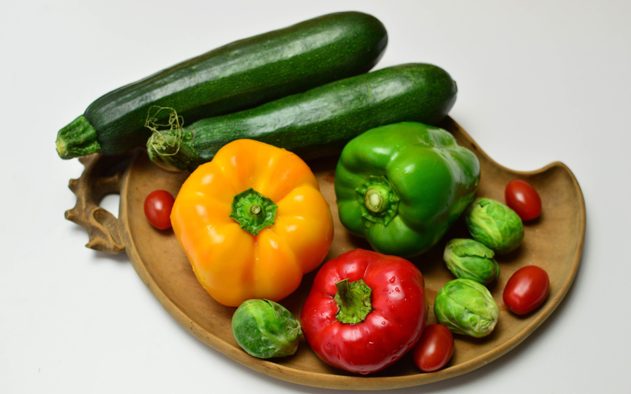Сладкий перец, кабачки, помидоры и брюссельская капуста на сером фоне