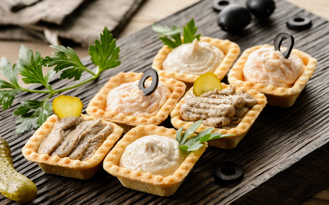 Тарталетки с паштетом на столе с оливками 